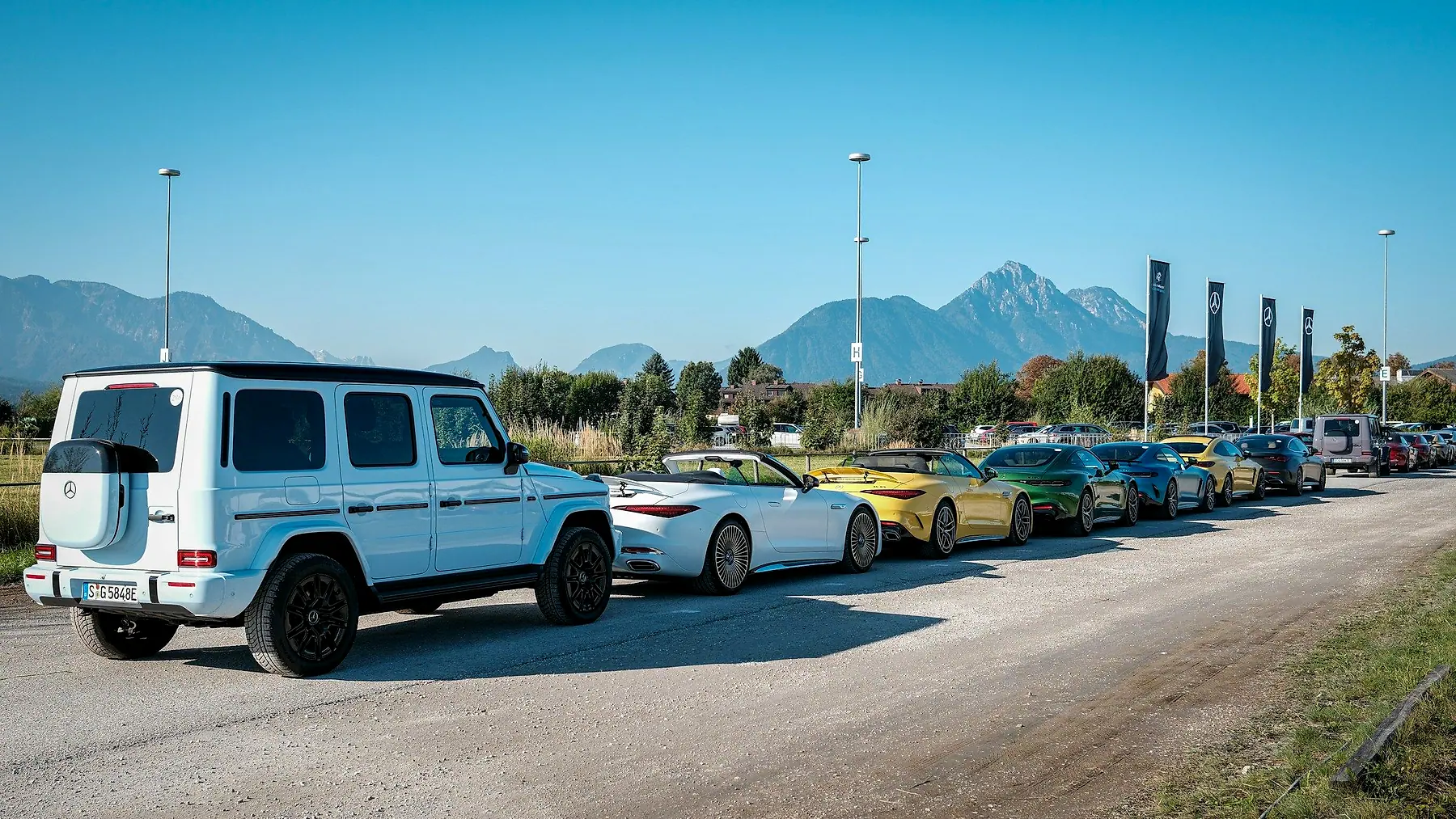 Cars parked in a row with mountains behind them