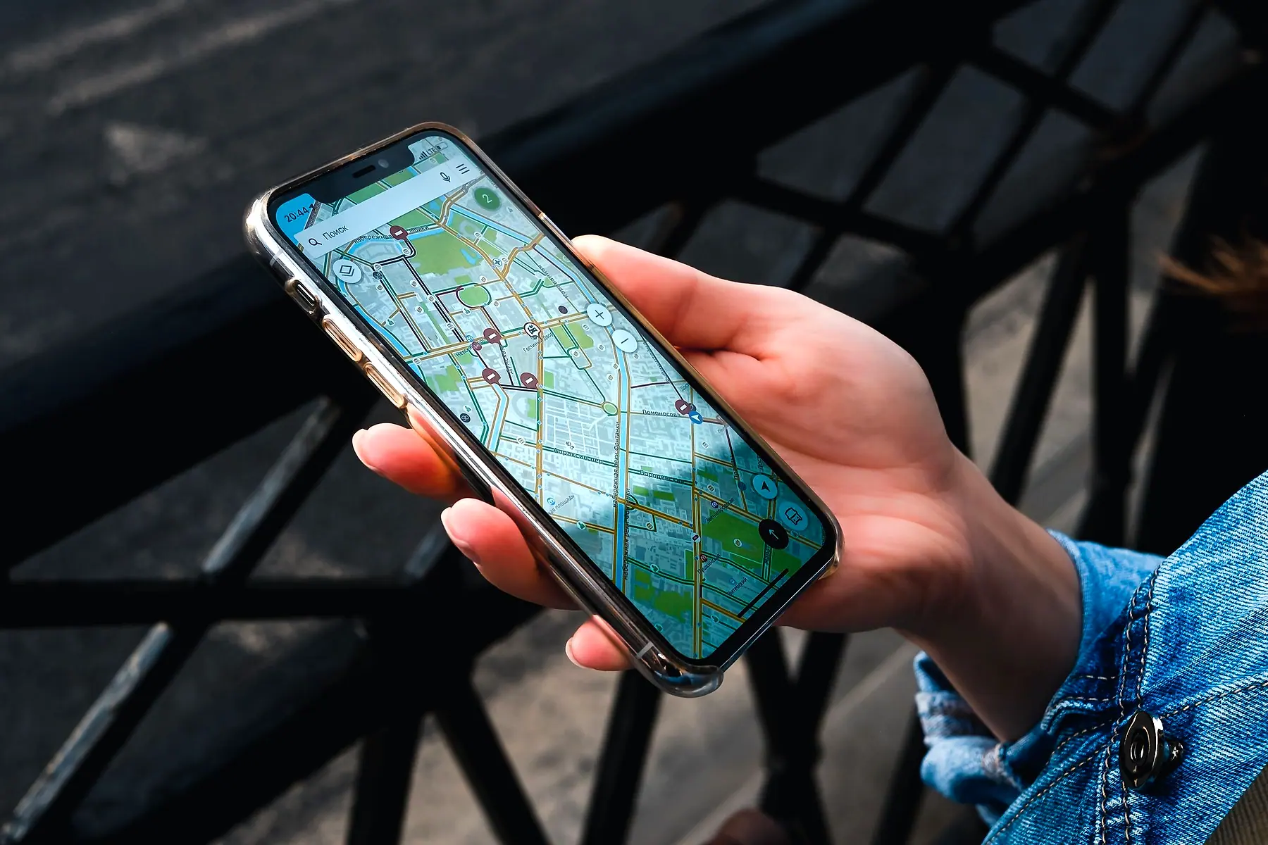A hand holding a phone showing a city map with places pinned on it