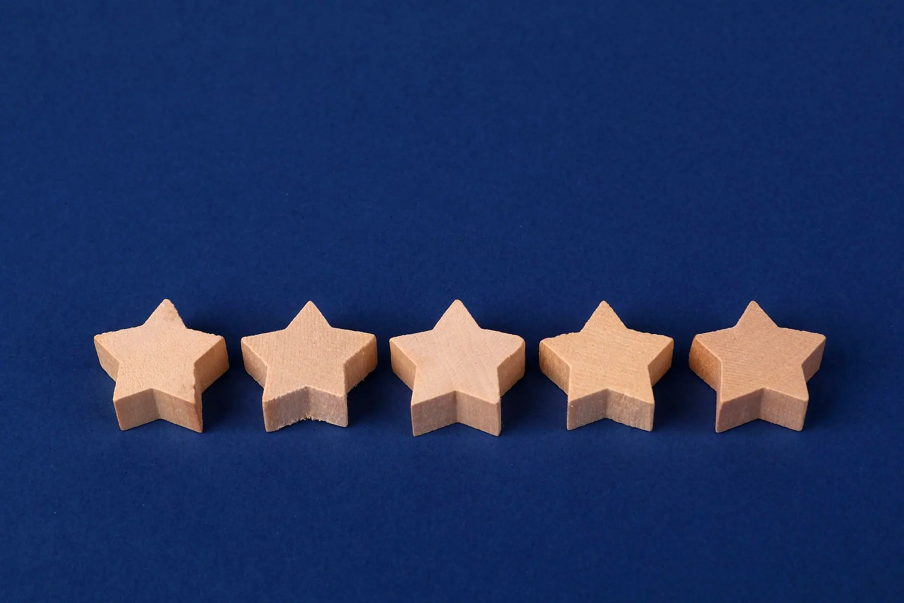 Five wooden stars in a row, a five-star rating