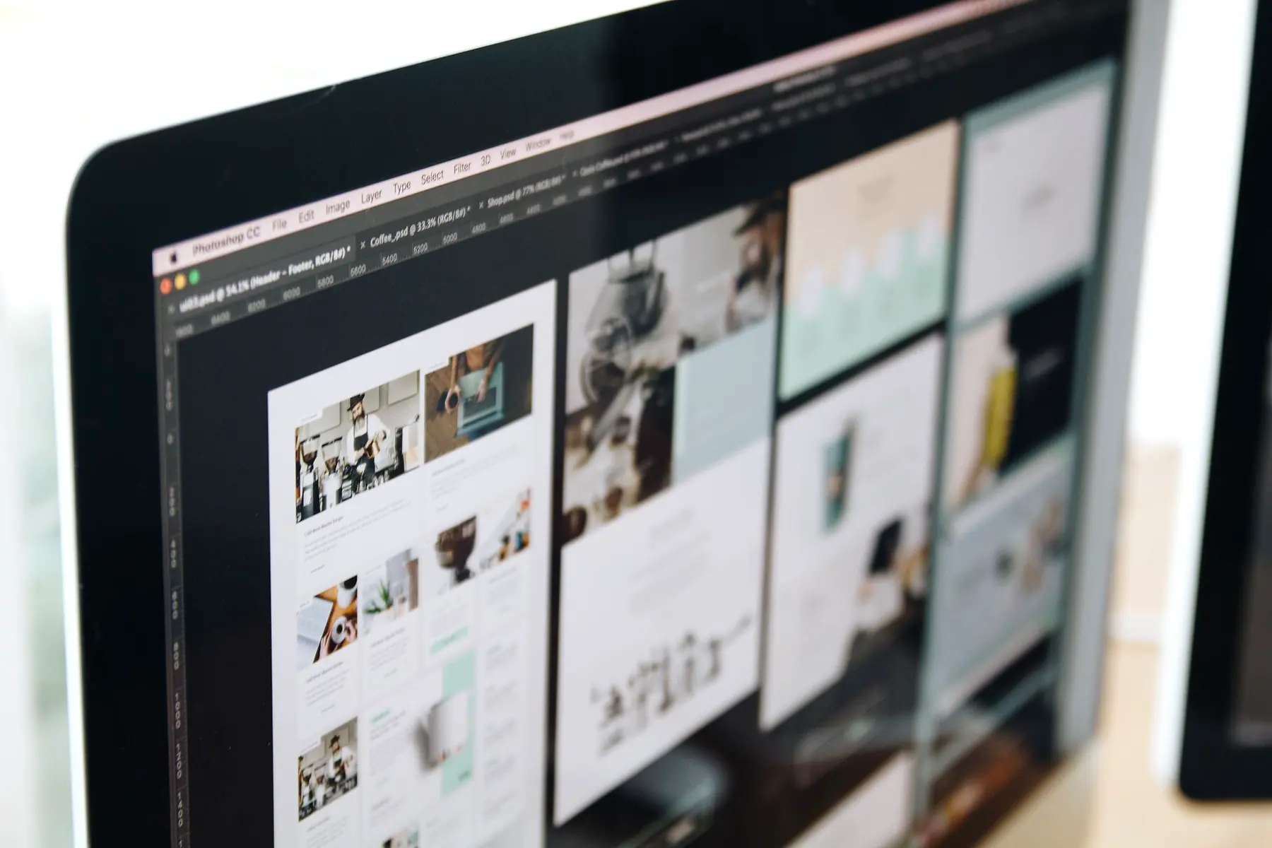 Website page layouts being designed on a large desktop monitor