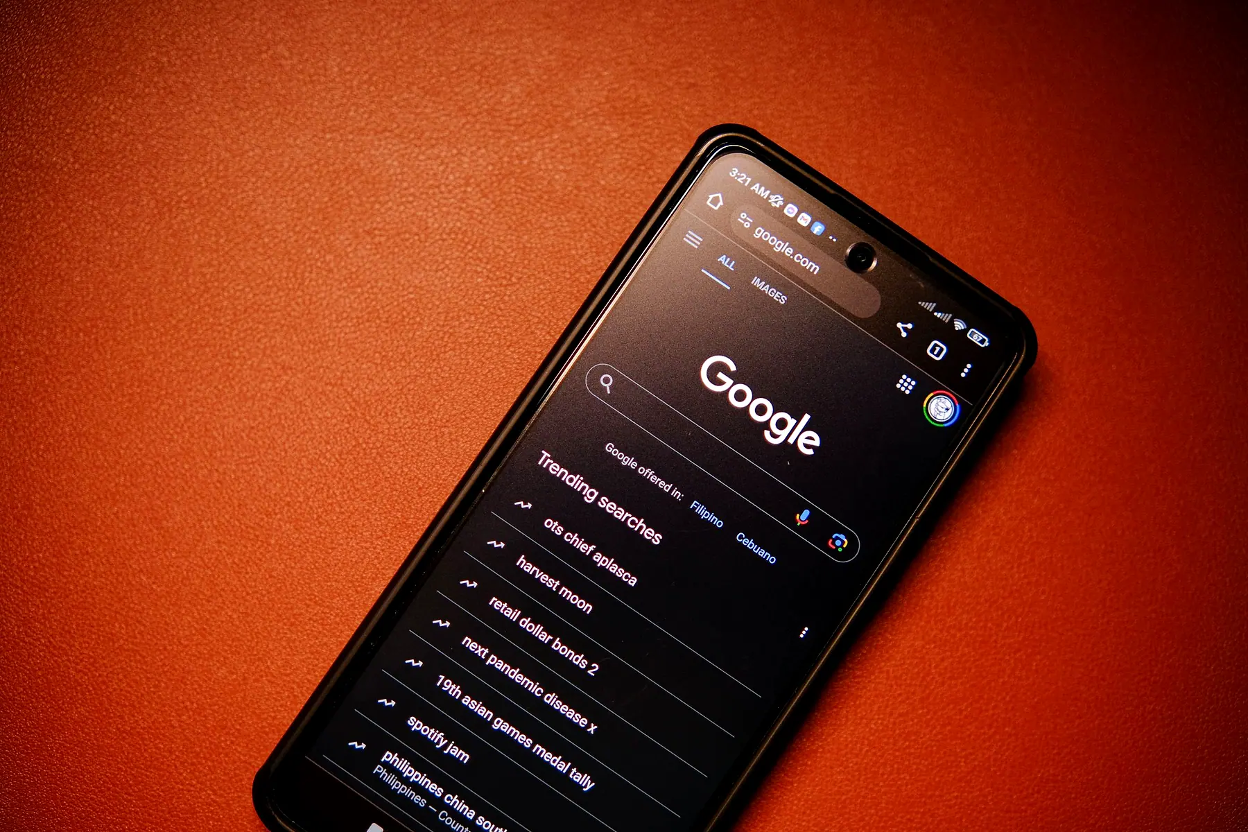 A phone showing a search engine on an orange background